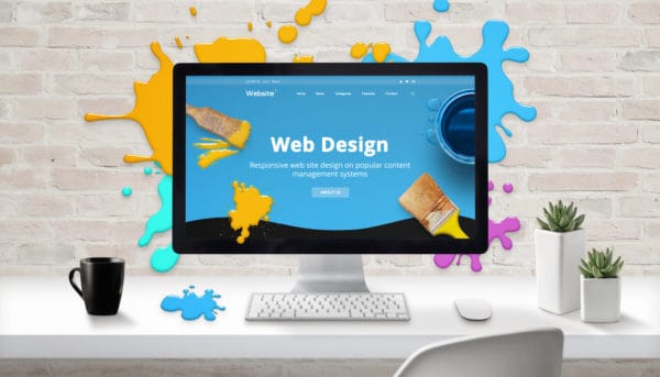 Web design concept. Modern web site on computer display surrounded by brush color drops.