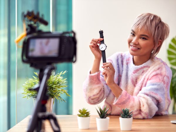 Photo of a customer doing a video review on a new watch, this is UGC. User Generated Content. 