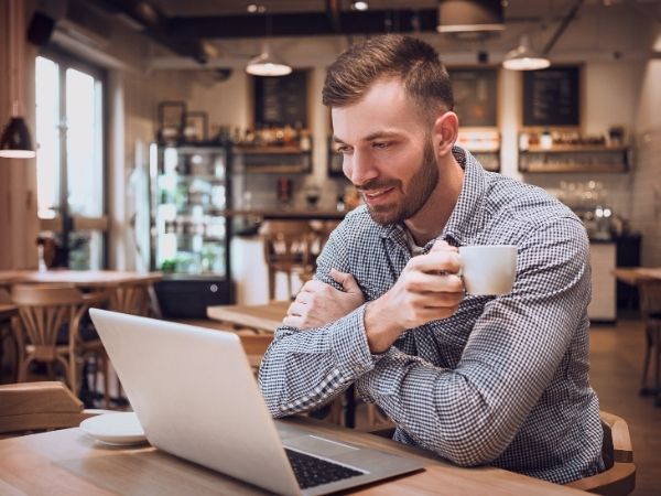 Local person searching for nearby allied health services on a laptop in a café, illustrating the importance of location-focused content