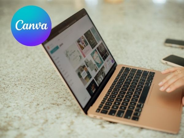 Open laptop on a speckled countertop showing Canva’s template interface on screen. Canva logo in the corner.