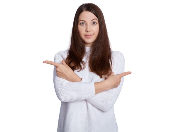 Young woman in a white jumper crosses her arms to points in opposite directions, Pointing to opportunities on one saide and risks on the other. 