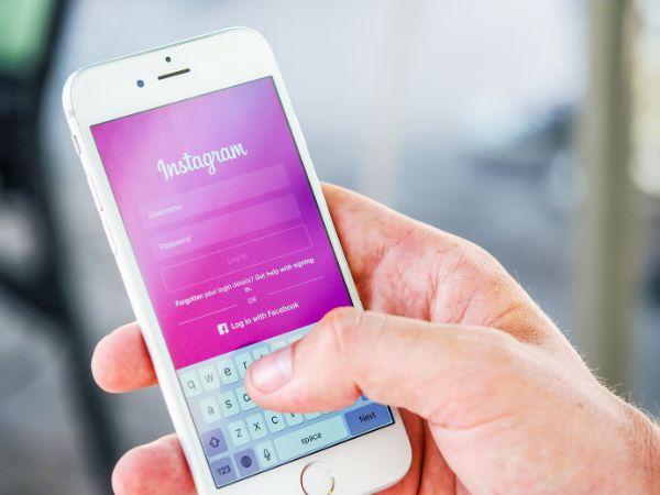 Close-up of a hand holding a smartphone that displays the Instagram login screen.