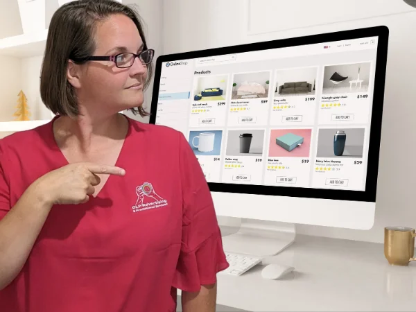 Ellie Clare from CLP Advertising pointing to a computer screen displaying an e-commerce website layout, representing the importance of having a professional online presence for business growth.